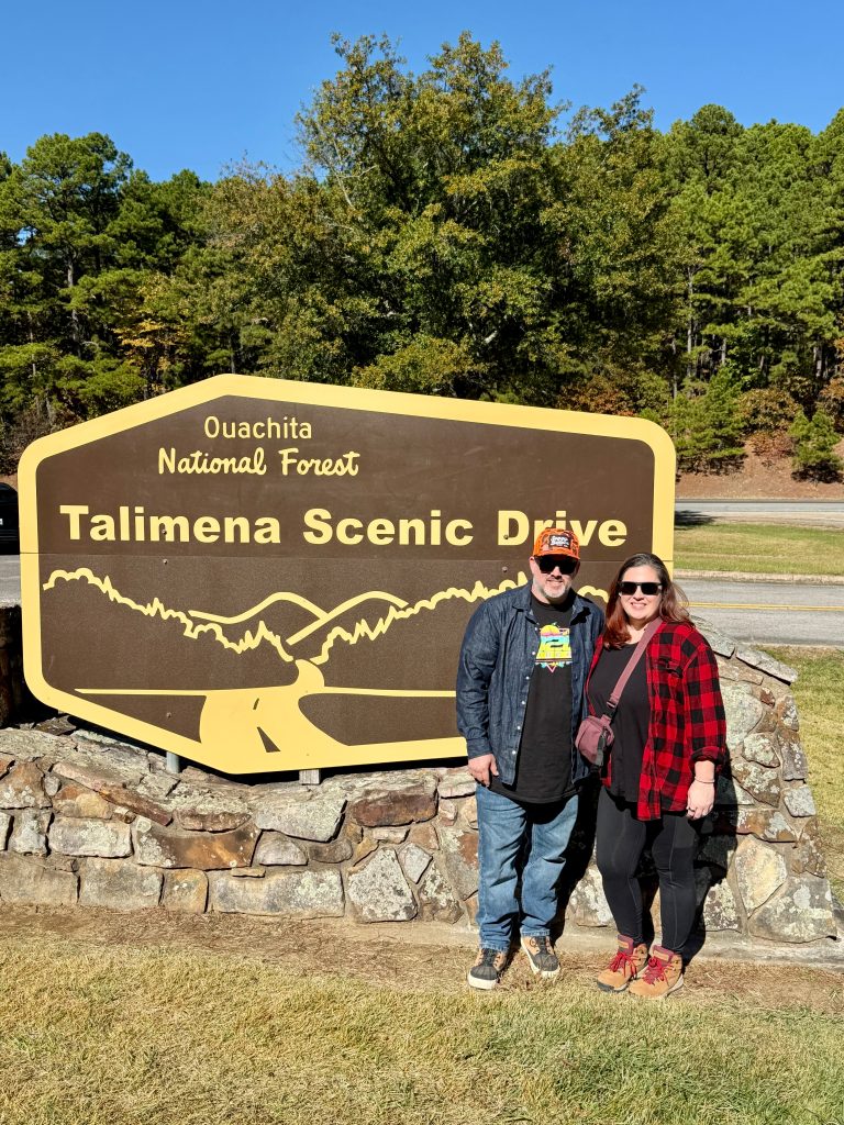 couple posing in front of the Talimena Scenic Byway sign